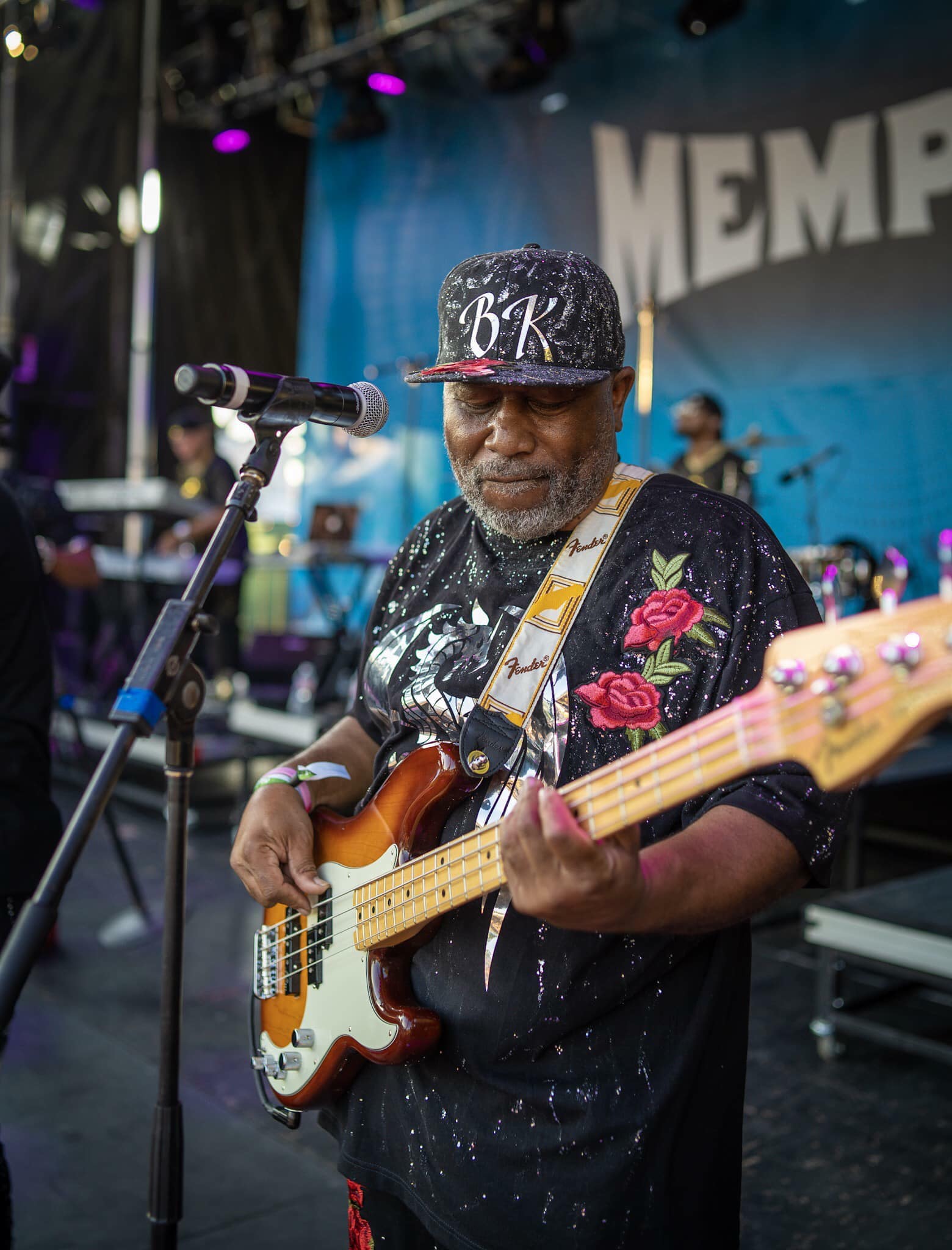 James Alexander on stage playing bass in a Bar-Kays cap at a Memphis festival